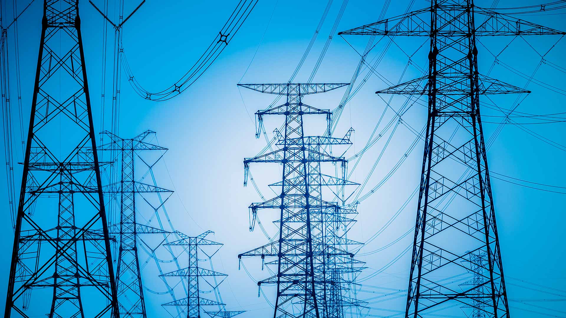 Silhouettes of power lines against blue background